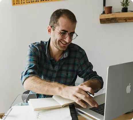 Man smiling while working on his laptop